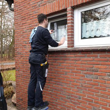 Mitarbeiter von Neesen Glas- und Innenreinigung reinigt ein Fenster